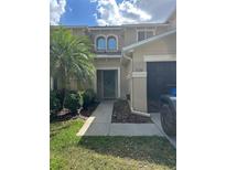 Inviting townhouse with a well-manicured lawn, mature landscaping, and an attached garage at 3132 Royal Tuscan Ln, Valrico, FL 33594