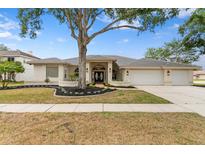 Beautiful single-story home with mature landscaping and a three-car garage at 3982 Wellington Pkwy, Palm Harbor, FL 34685