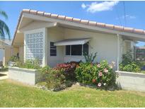 Cozy single-story home featuring a tile roof and pretty landscaping in the front yard at 5105 Bonito Dr, New Port Richey, FL 34652