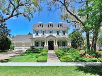 Charming three-story home featuring a manicured lawn, symmetrical design, and classic architectural details at 5318 Candler View Dr, Lithia, FL 33547