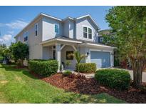 Charming two-story home with a well-manicured lawn, mature trees, and a welcoming front entrance at 5910 Caldera Ridge Dr, Lithia, FL 33547