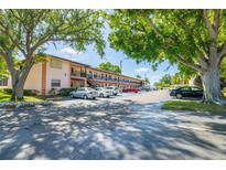 Apartment building exterior view shows parking and mature trees at 13250 Ridge Rd # 4B3, Largo, FL 33778