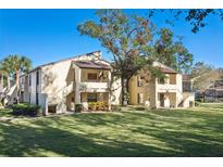 Inviting condominium complex showcasing well-maintained lawns, mature trees, and charming architectural details at 13608 S Village Dr # 6203, Tampa, FL 33618