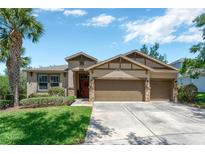 Inviting home with a well-manicured lawn, three-car garage, and mature landscaping at 15635 Starling Water, Lithia, FL 33547