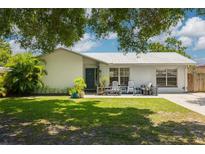 Charming single-story home featuring a metal roof, cozy front porch, and lush green lawn at 2153 Catalina N Dr, Clearwater, FL 33763