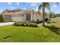 Beautiful single-story home with lush landscaping, well-manicured lawn, and attached two-car garage at 25830 Crippen Dr, Land O Lakes, FL 34639