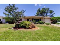 Charming home featuring a lush green lawn and mature landscaping, creating inviting curb appeal at 2800 54Th N St, St Petersburg, FL 33710