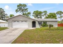 Charming single-story home featuring an attached two-car garage and well-maintained front lawn at 3353 Montano Ave, Spring Hill, FL 34609
