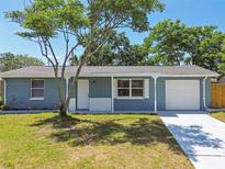Charming one-story home with blue siding, a new driveway, and a well-manicured front yard at 4940 Rosedale Ln, Holiday, FL 34690