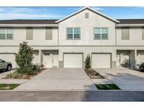 A modern townhouse featuring attached garages and neutral exterior paint at 6306 Tillandsia Pl, Tampa, FL 33610