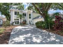 Stately two-story home featuring stucco exterior, manicured landscaping, and a circular driveway at 9315 Knightsbridge Ct, Tampa, FL 33647