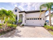 Stunning home featuring a beautiful brick driveway, attached two-car garage, and lush tropical landscaping at 1015 Seagrape Dr, Ruskin, FL 33570