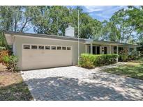 Charming single story home with a 2-car garage and a well-manicured lawn at 1242 Nelson St, Dunedin, FL 34698