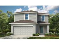 Two-story home featuring a two-car garage, gray siding, and a cozy front porch surrounded by lush landscaping at 13273 Tropical Breeze Way, Hudson, FL 34669