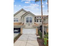 Attractive two-story townhome featuring a tile roof, two-car garage, and stone accents at 14537 Mirabelle Vista Cir, Tampa, FL 33626