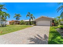 Charming single-story home with a spacious driveway, well-manicured lawn, and lush tropical landscaping at 1941 Kentucky Ne Ave, St Petersburg, FL 33703