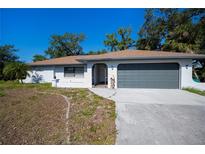 Charming single-story home with a two-car garage and a well-maintained front lawn at 2167 Corfell St, Port Charlotte, FL 33948