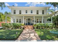 Inviting two-story home with a spacious front porch, manicured lawn, and brick pathway at 2523 W Sunset Dr, Tampa, FL 33629