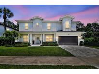 Charming two-story home featuring white siding, manicured lawn, and a beautiful, colorful sunset backdrop at 3905 W San Obispo St, Tampa, FL 33629