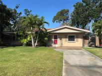 Charming single Gathering home with a well-manicured lawn and mature trees, with a cozy red door at 4218 Carson Ne St, St Petersburg, FL 33703