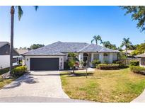 Charming single-story home with a well-maintained lawn, brick driveway, and a two-car garage at 4822 Hamlets Grove Dr, Sarasota, FL 34235