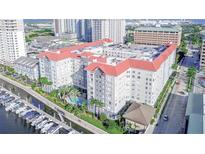 Luxury condo building with a red roof, waterfront access, boat docks, and a refreshing pool surrounded by lush landscaping at 700 S Harbour Island Blvd # 342, Tampa, FL 33602