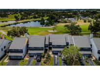 An aerial view of a townhome community situated on a golf course with water views at 9050 Park Blvd # 5, Seminole, FL 33777