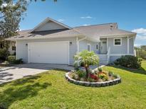 Charming single Gathering home with a well-maintained front yard and a two-car garage at 1015 S Pointe Alexis Dr, Tarpon Springs, FL 34689