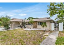 Charming single-story home featuring a stone accent wall and manicured landscaping at 1403 Garden Ave, Tarpon Springs, FL 34689