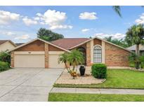 Charming one-story home featuring a well-manicured lawn and a two-car garage at 1831 Stable Trl, Palm Harbor, FL 34685
