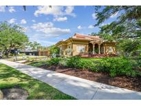 Charming brick home with red tile roof, landscaped front yard, and inviting front porch at 2710 N Dundee St, Tampa, FL 33629