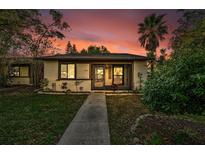 Charming single-story home featuring a welcoming front yard with lush landscaping and a serene setting at sunset at 2945 Grovewood Blvd # D, Palm Harbor, FL 34683