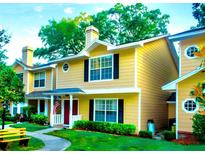 Inviting exterior of a charming yellow townhome with black shutters and manicured lawn at 3086 Pointer Dr, Palm Harbor, FL 34683