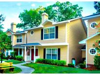 Inviting two-story townhouse featuring a well-maintained lawn and charming exterior details at 3086 Pointer Dr, Palm Harbor, FL 34683