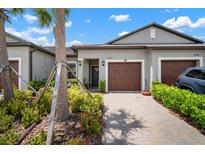 Charming townhome with a two-car garage and lush landscaping, creating a welcoming curb appeal at 31354 Cabana Rye Ave, San Antonio, FL 33576