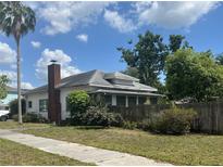 Quaint single-story home featuring a red brick chimney, well-maintained lawn, and charming curb appeal at 3210 W North B St, Tampa, FL 33609