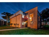 Two-story condo with stucco exterior, complemented by lush greenery and a well-maintained lawn at 4805 Alt 19 # 421, Palm Harbor, FL 34683