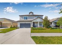 Charming two-story home features a well-manicured lawn, attached garage, and inviting entryway at 4808 Jackson Club Loop, Tampa, FL 33624