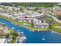 Waterfront condo complex featuring a pool, marina, and lush landscaping at 5157 Silent Loop # 214, New Port Richey, FL 34652