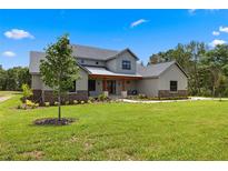 Charming two-story home featuring a landscaped front yard, stone accents, and a welcoming front porch at 5865 Creek Ridge Rd, Brooksville, FL 34601