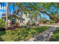 Charming home featuring lush landscaping, a sidewalk, and a well-maintained lawn at 640 Kenneth Way, Tarpon Springs, FL 34689