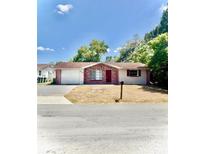 Charming single-story home with brick accents, a well-manicured lawn, and an attached garage at 7734 Judith Cres, Port Richey, FL 34668