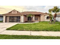 Charming single-story home with well-manicured lawn, stone accents, and an attached two-car garage at 8127 Tarsier Ave, New Port Richey, FL 34653