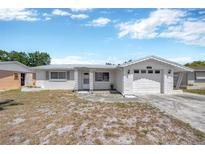 Charming single-story home featuring a classic design and a well-maintained front yard in a quiet neighborhood at 1408 Dartmouth Dr, Holiday, FL 34691