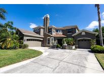 Stately home features a stone chimney, two-car garage, and circular driveway at 16637 Ashton Green Dr, Lutz, FL 33558