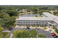 Condo building with ample parking overlooking a serene lake and lush trees at 2228 Swedish Dr # 22, Clearwater, FL 33763