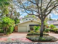 Charming home with a brick driveway, attached garage, and beautifully landscaped front yard at 246 22Nd Ne Ave, St Petersburg, FL 33704