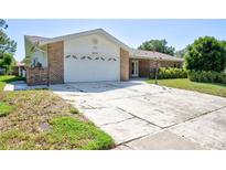 Charming single-story home featuring a spacious two-car garage and traditional brick accents at 2675 Firestone Dr, Clearwater, FL 33761