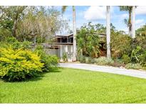 Inviting home featuring lush landscaping and a long driveway leading to a mid-century modern home at 3130 Walnut Ne St, St Petersburg, FL 33704