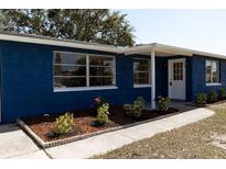 Charming single-story home featuring a blue exterior, well-maintained landscaping, and a welcoming front entrance at 3530 Umber Rd, Holiday, FL 34691
